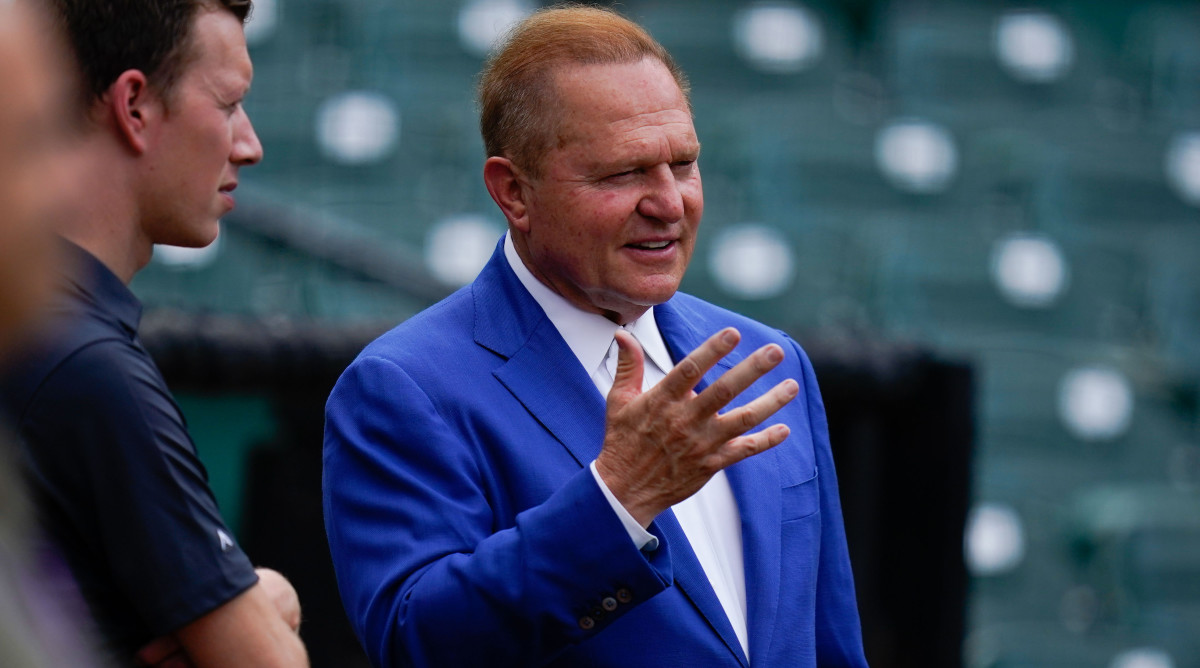Scott Boras gestures with his hand while stands on the field before the game